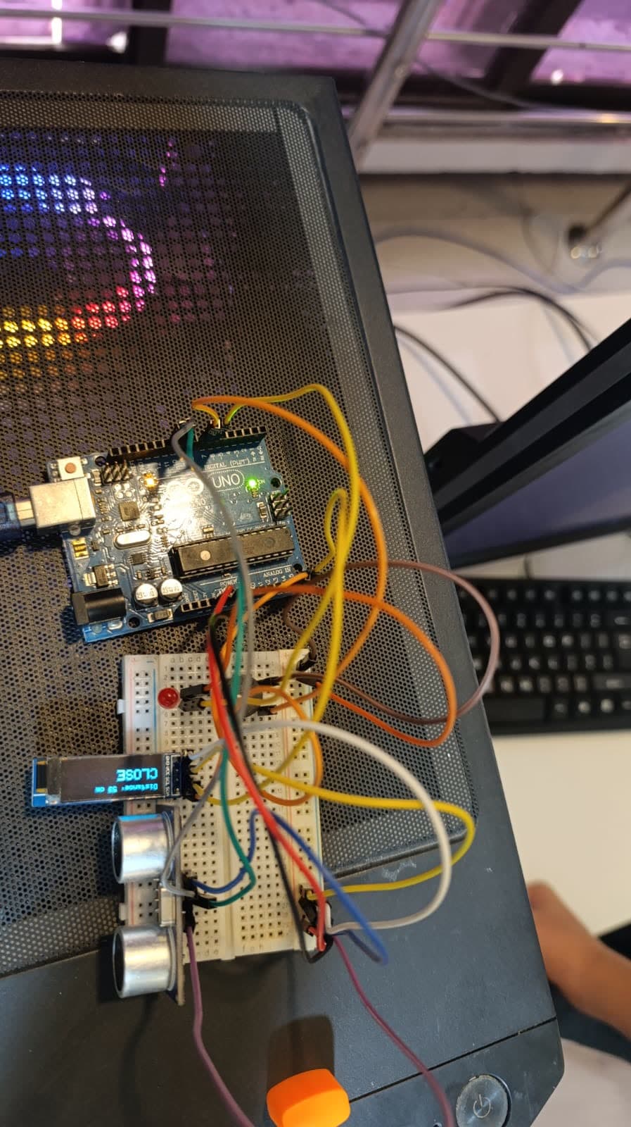 An ultrasonic distance sensor with an OLED display showing the measured distance, on a breadboard
