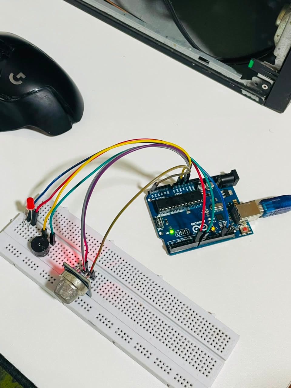 An MQ-2 gas sensor, LED and buzzer wired to an Arduino Uno on a breadboard